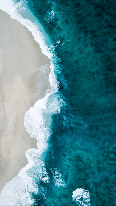 Top down shot of waves crashing on a beach