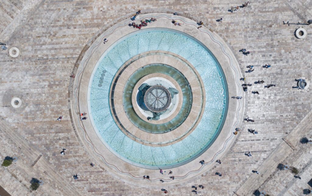 a circular fountain with people around it