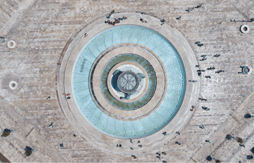 a circular fountain with people around it