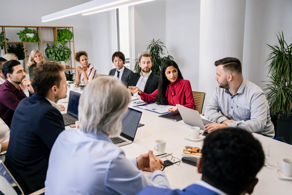 A diverse group of professionals discussing ideas and collaborating at a meeting table.