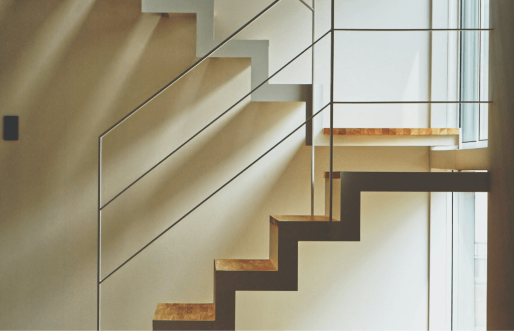 A staircase with sleek metal railings and sturdy wooden stairs.