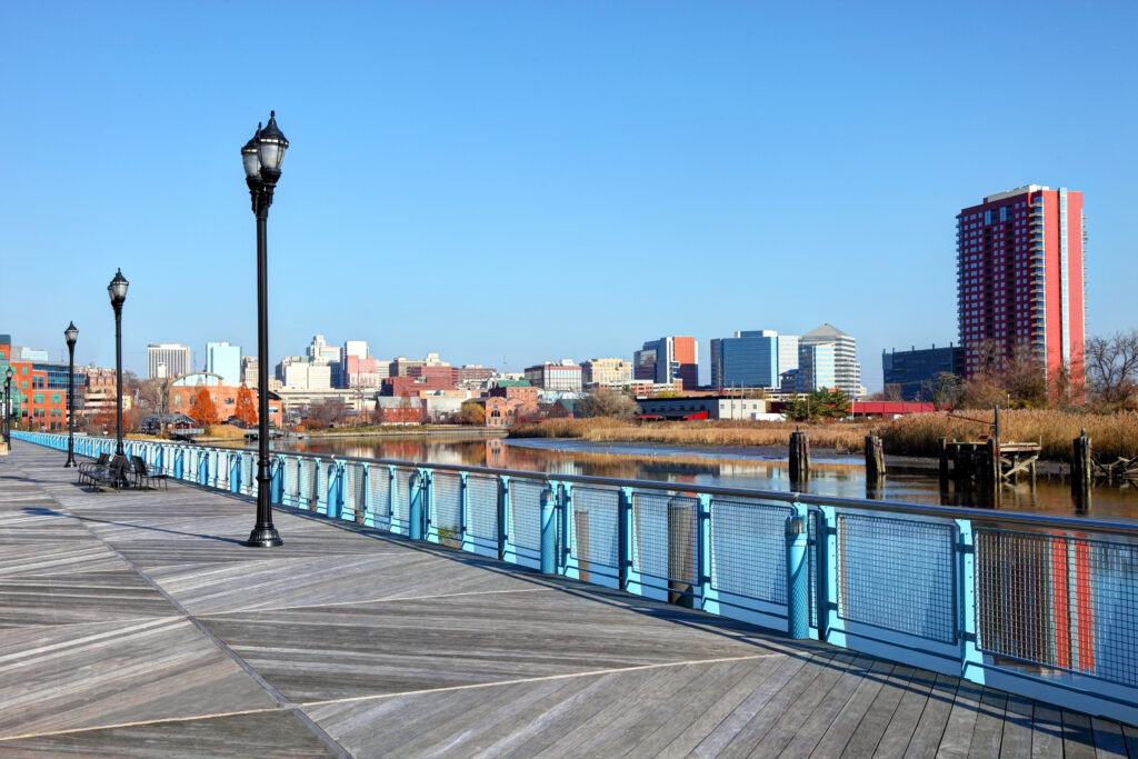 A scenic boardwalk with a stunning city skyline in the background. Enjoy a leisurely stroll by the water's edge.