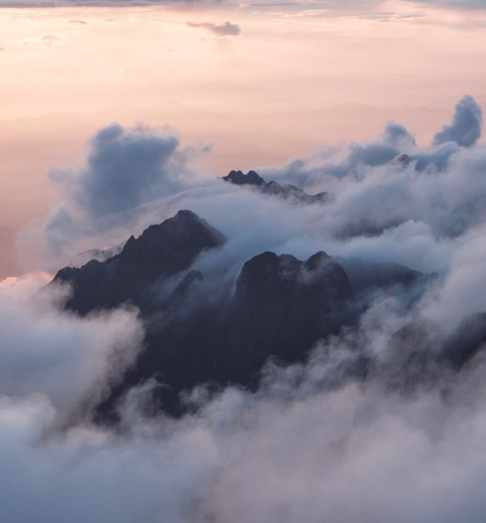 Mountains at sunset, shrouded in clouds. A breathtaking view of nature's beauty and tranquility.