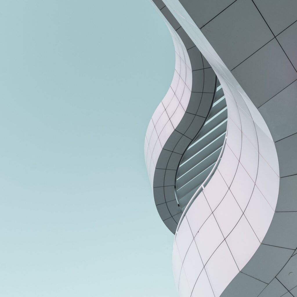 A stunning curved building against a vibrant blue sky.