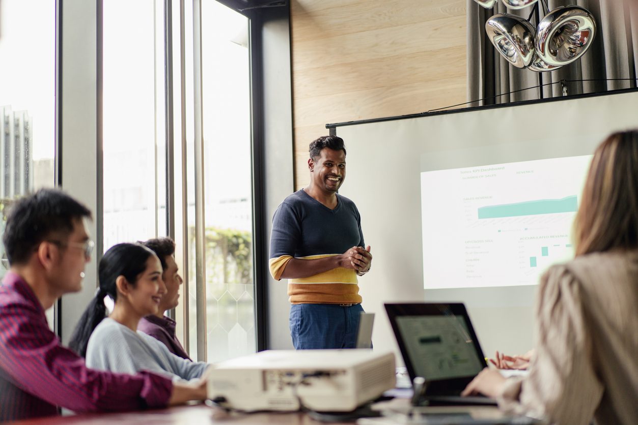 A man presenting to a group of people, engaging them with his informative and captivating speech.