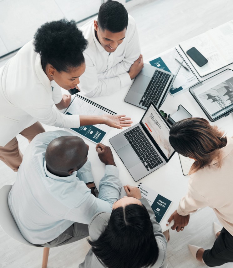 A group of people collaborating on a laptop, sharing ideas and working together as a team.