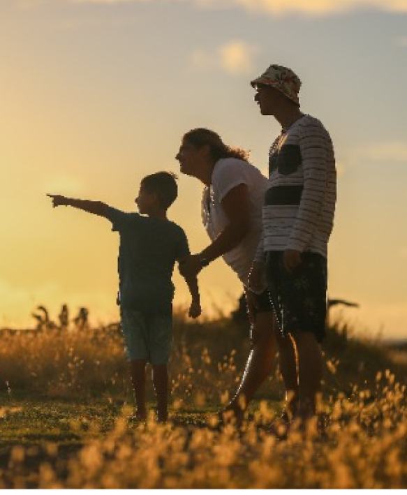 A beautiful family posing together, silhouetted against a stunning sunset backdrop. Love and togetherness captured in a single frame.