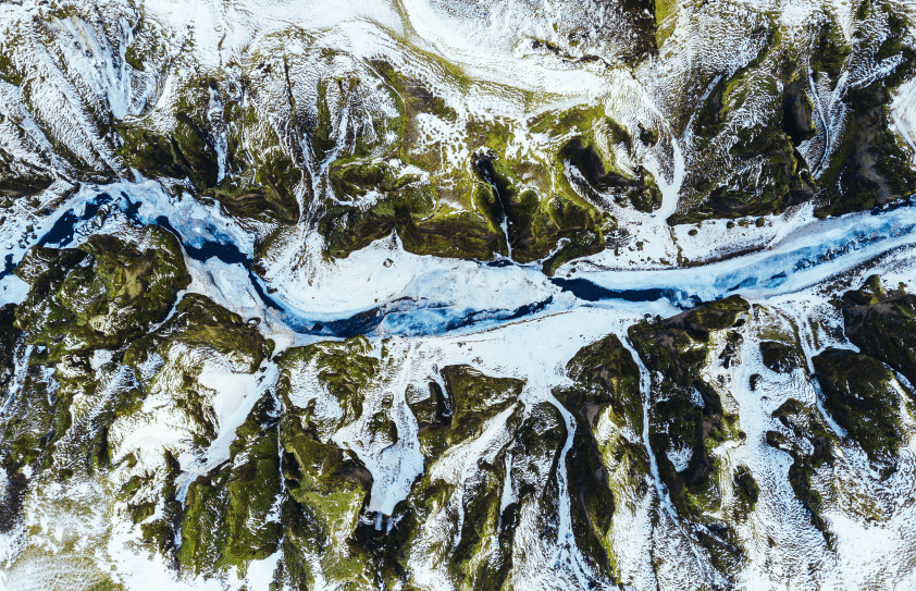 Top down image of mountain range with snow near a river