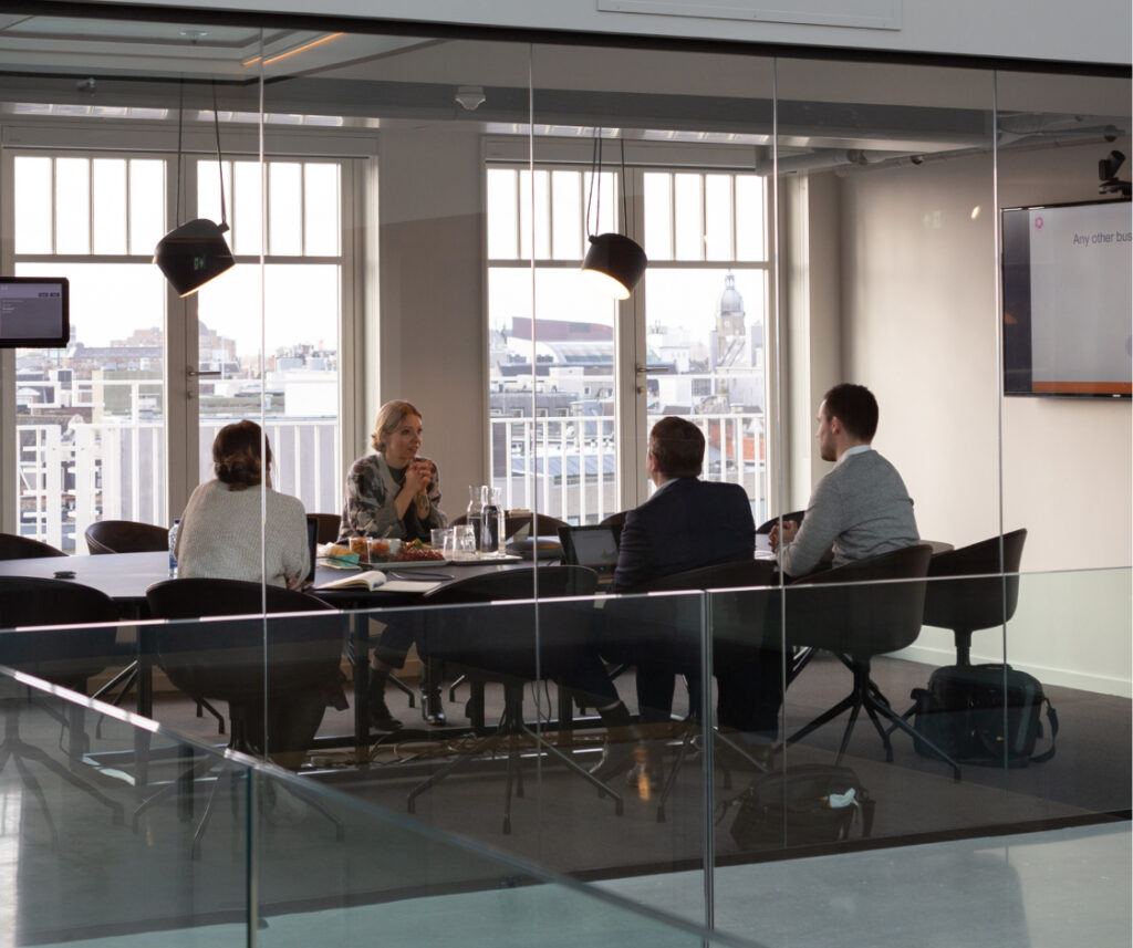 Professionals gathered around a table, exchanging thoughts and brainstorming in a conference room setting.