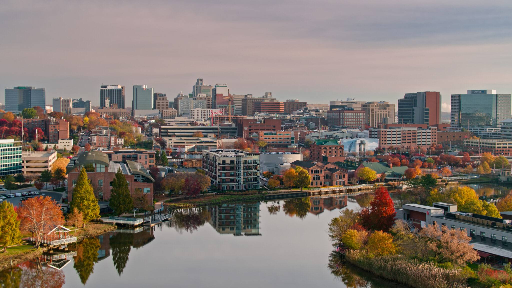 Aerial establishing shot of Wilmington, Delaware on a cloudy Fall morning, looking along the Christina River towards the downtown skyline.