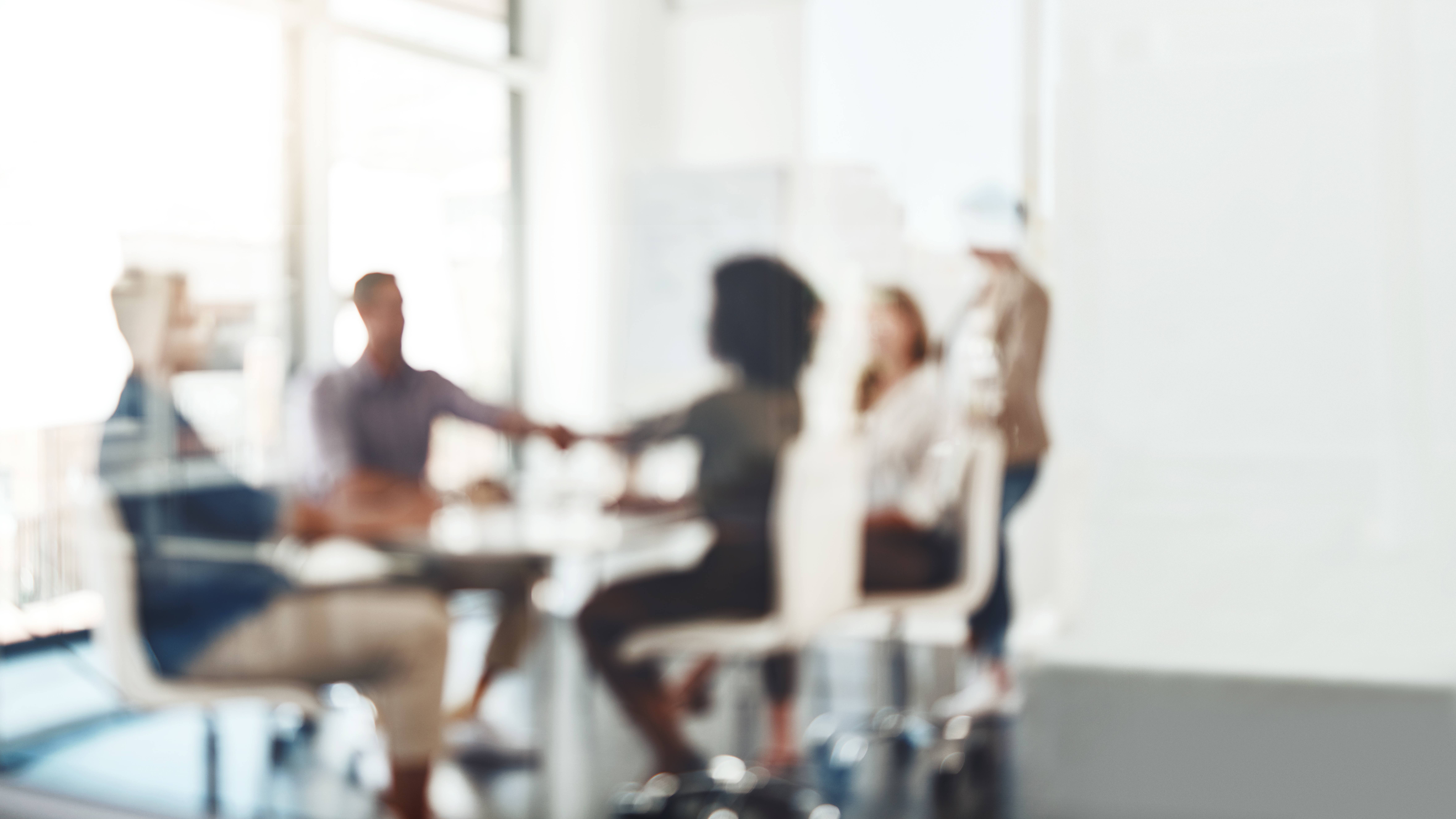 Defocused shot of businesspeople shaking hands during a meeting in an office