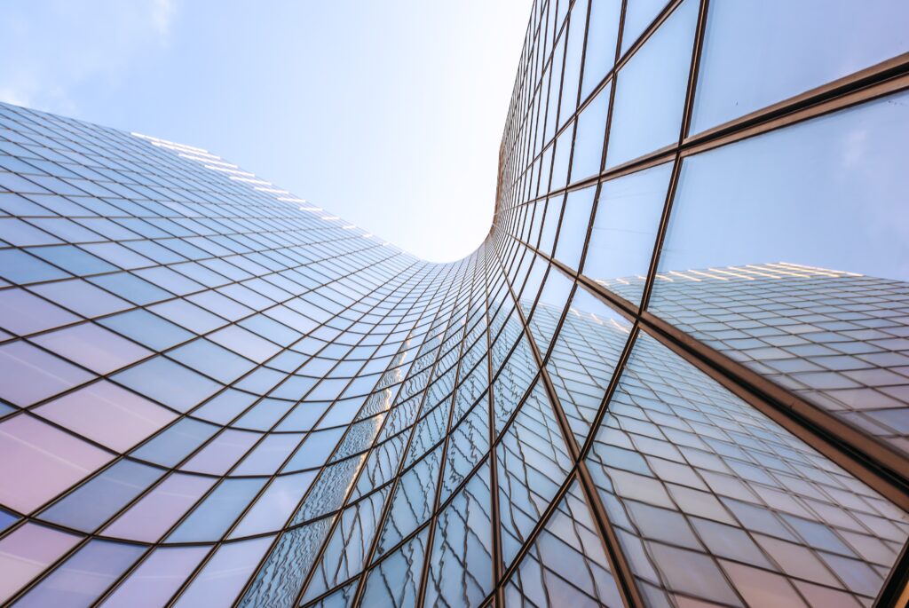 Blue sky reflecting on a curved glass skyscraper low angle view